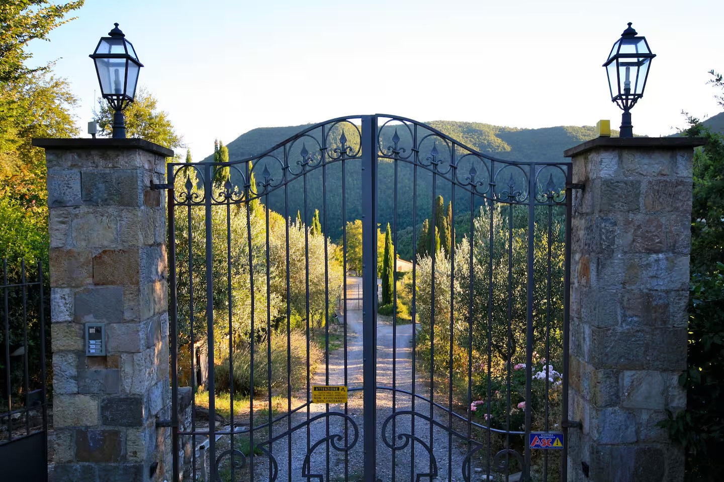 Iron entry gates opening onto the Tuscan countryside